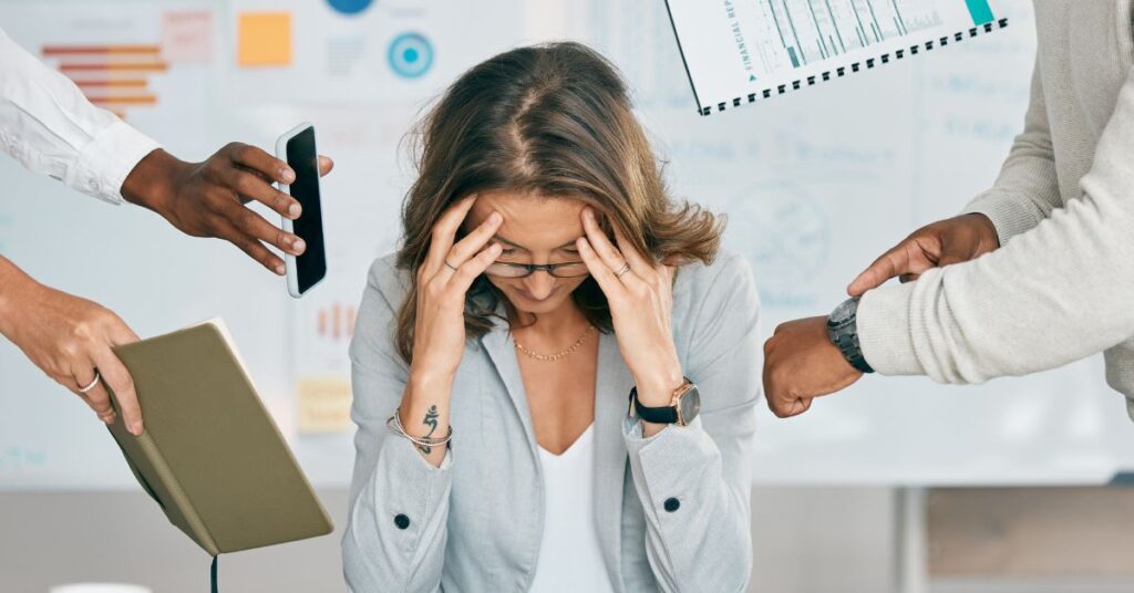 Lady at desk feeling overwhelmed by work