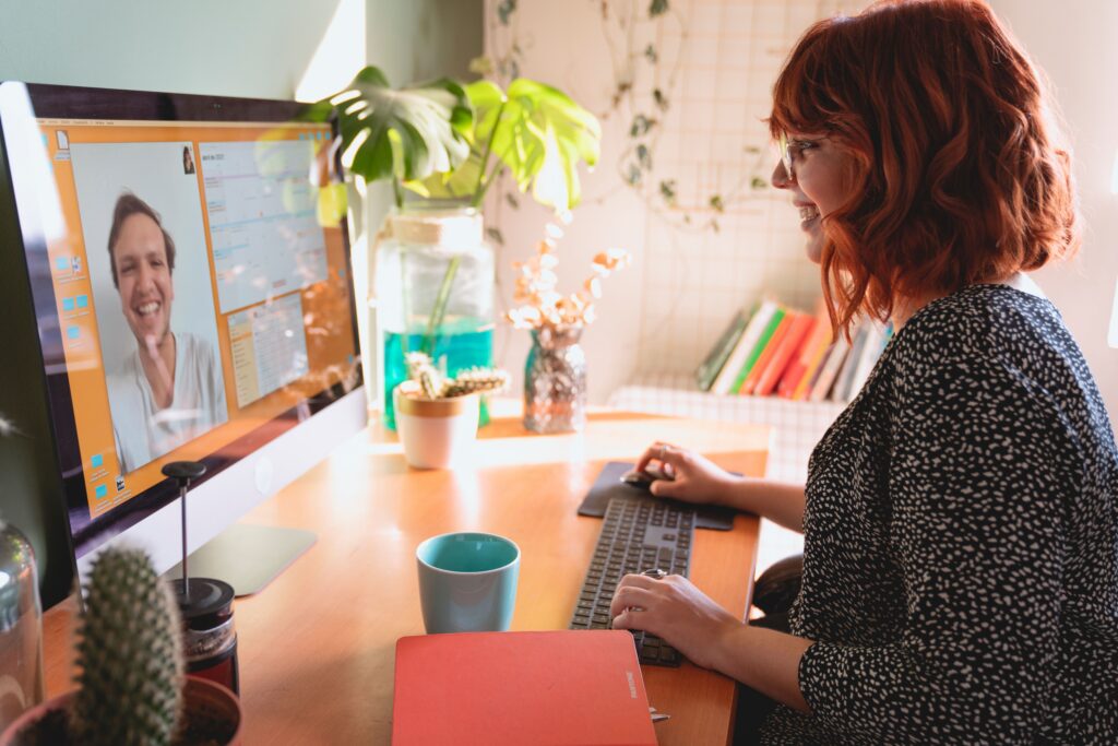 pexels photo 7616804 7616804 A woman video communicates from a sunny home office, enjoying a remote work setup.