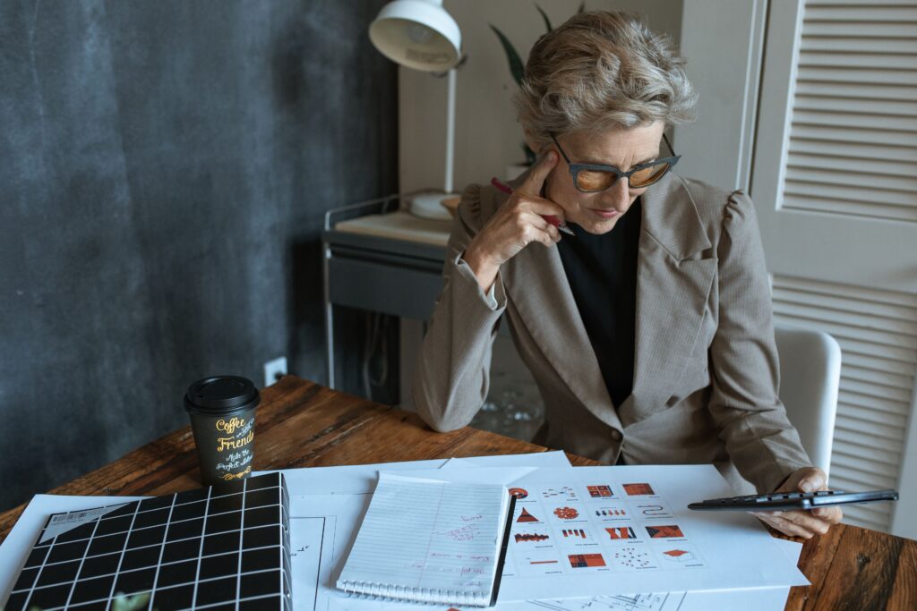 pexels photo 5915298 5915298 Focused businesswoman reviewing documents at desk in modern home office setting.