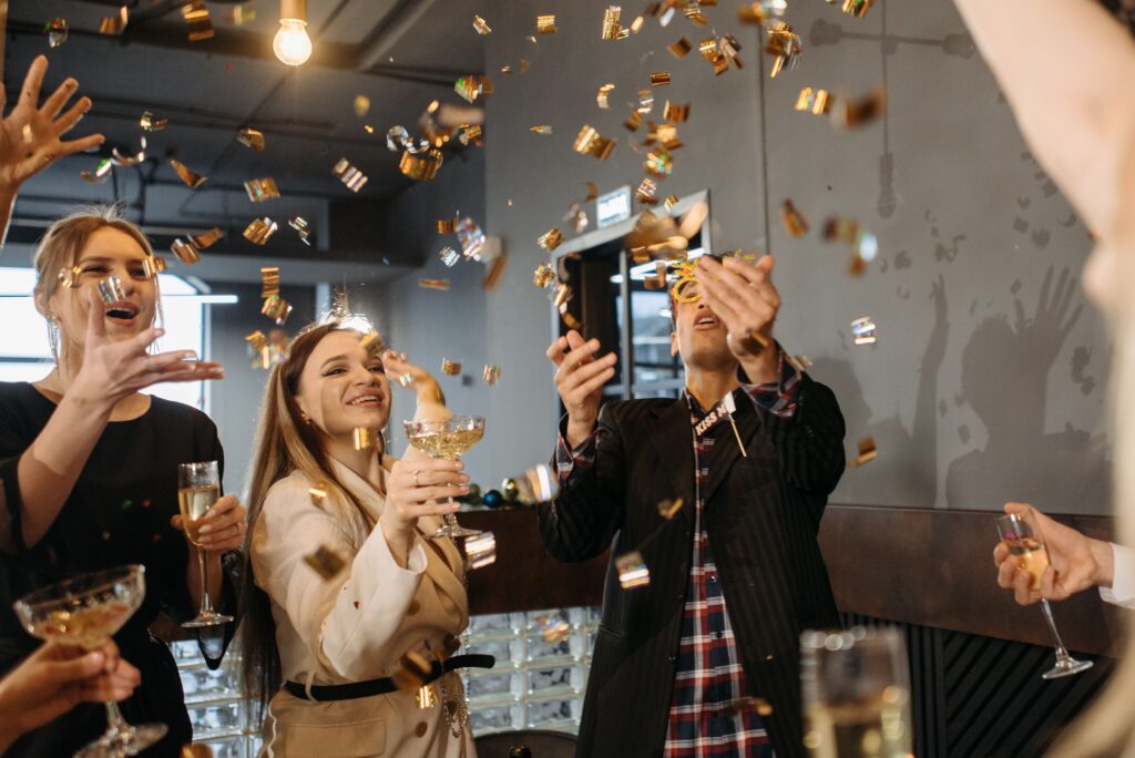 pexels photo 6405773 6405773 Group of colleagues celebrating indoors with champagne and confetti, capturing joy and togetherness.
